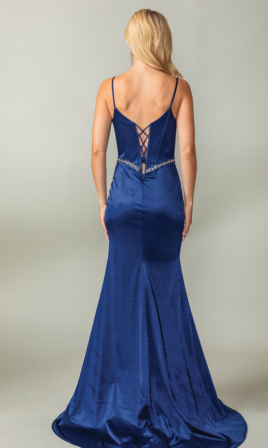Woman models the Beaded-Waist Long Corset-Back Prom Dress 4403—a floor-length, dark blue satin mermaid gown with spaghetti straps, sweetheart corset bodice, lace-up back, and beaded waist—against a plain backdrop.